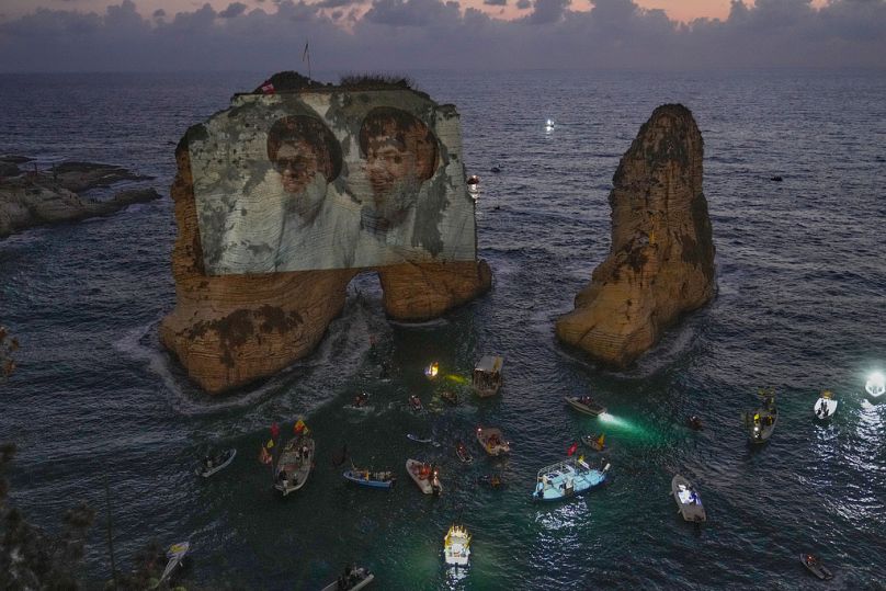 صورتان للأمينين العامين السابقين لـ"حزب الله" حسن نصر الله (يمينًا) وهاشم صفي الدين، على صخرة الروشة في بيروت خلال فعالية إحياء ذكرى اغتيالهما في 25 سبتمبر 2025.