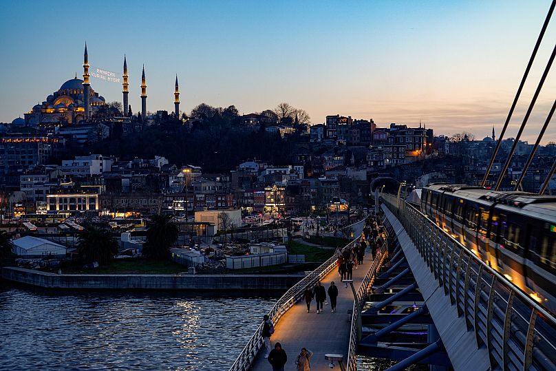 Arka planda Süleymaniye Camii gözüküyor, yayalar Haliç Köprüsü metro istasyonunda yürüyor, 2024.