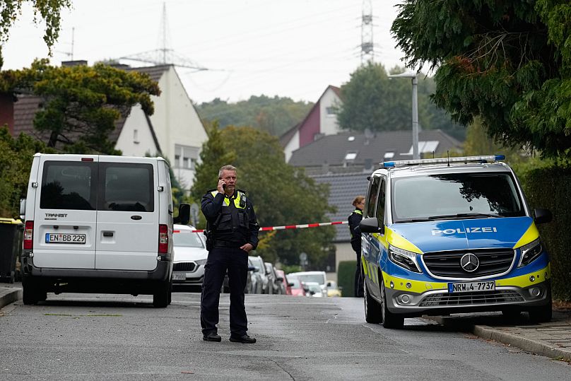 A police officer talks on his phone at a street in Herdecke, 7 October, 2025