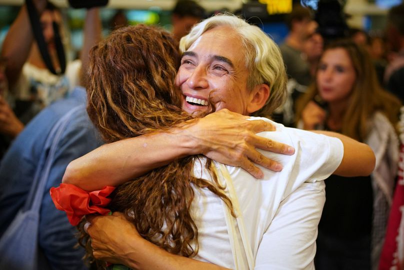 L'ex sindaca di Barcellona Ada Colau abbracciata da un'amica al suo arrivo all'aeroporto di Barcellona, in Spagna, domenica 5 ottobre 2025