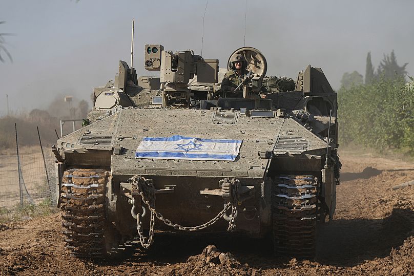 A convoy of Israeli army vehicles maneuvers near Israel's border after leaving Gaza, 24 November 2023
