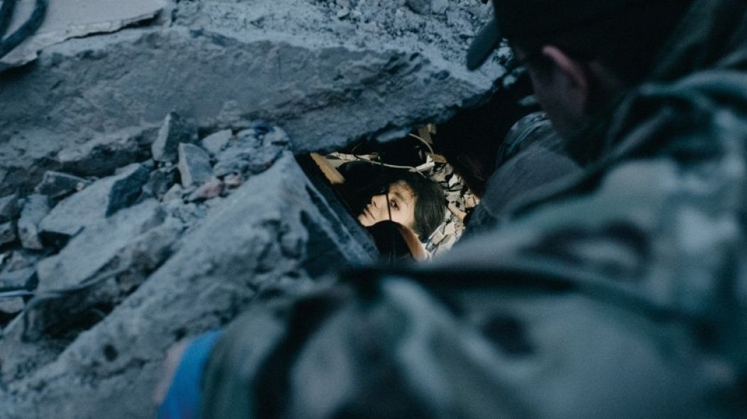 Irina, a waitress injured in a Russian rocket attack on the Ria Pizza restaurant in Kramatorsk, eastern Ukraine, waits to be rescued under rubble. Thirteen people were killed in the shelling.