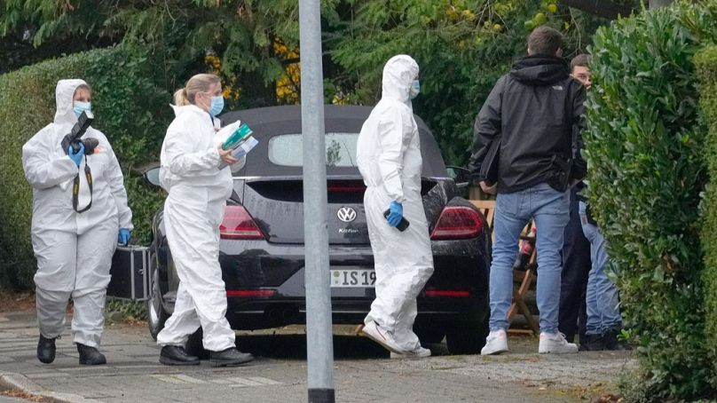 Forensic investigators appear at the crime scene at a street in Herdecke, Germany, Tuesday, Oct. 7, 2025.