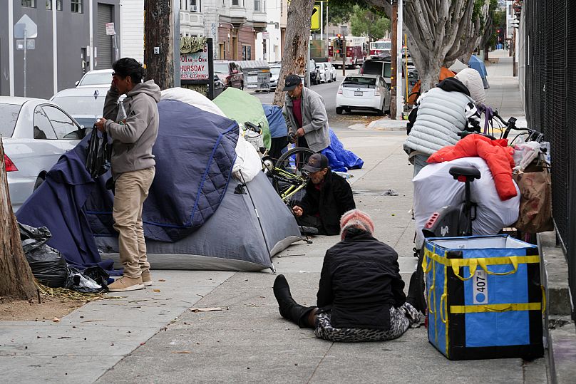 Homeless people gather with their belongings and tents in the Mission District of San Francisco, 10 September, 2024
