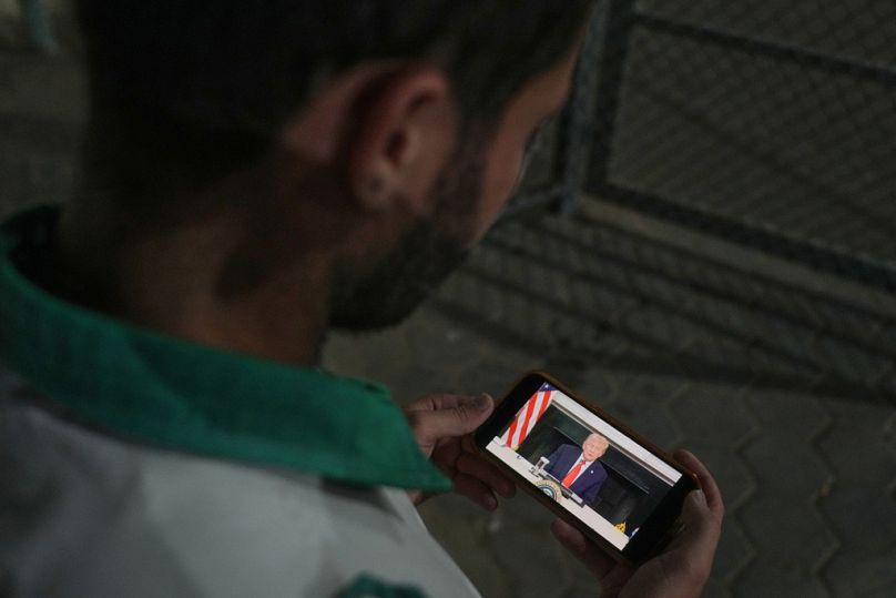 Gazze Şeridi'nde bir sağlık çalışanı ABD Başkanı Donald Trump'ın açıklamalarını telefonundan takip ediyor, 9 Ekim 2025