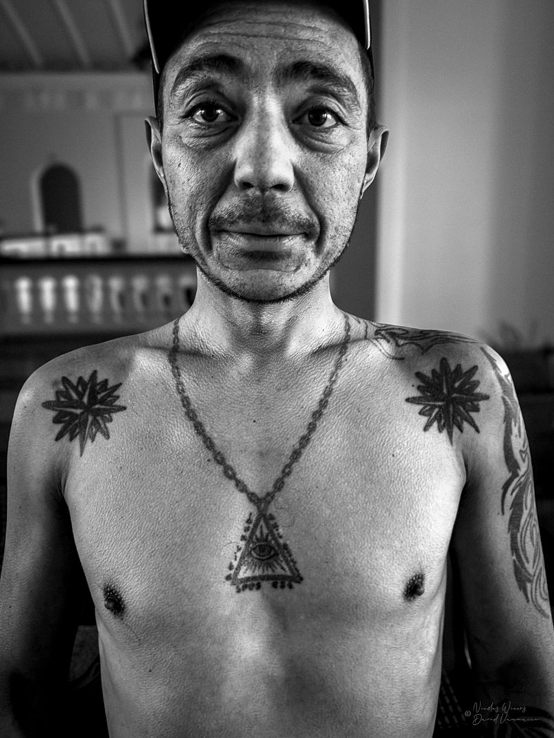 A man show his tattoos as part of the 'Surrounded by Criminals' exhibition 