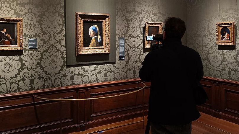 A video journalist takes images of "Girl with a Pearl Earring," painting by Johannes Vermeer, at The Mauritshuis museum in The Hague. Photo by Molly Quell.