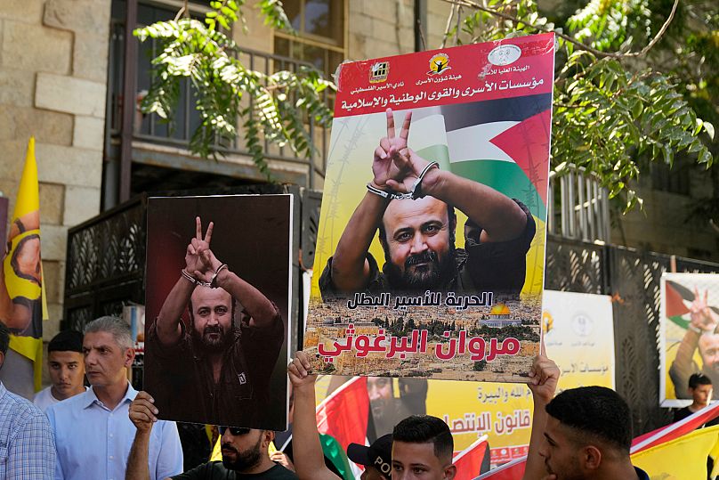 Supporters of popular Palestinian leader Marwan Barghouti carry posters in the West Bank city of Ramallah, 19 August, 2025