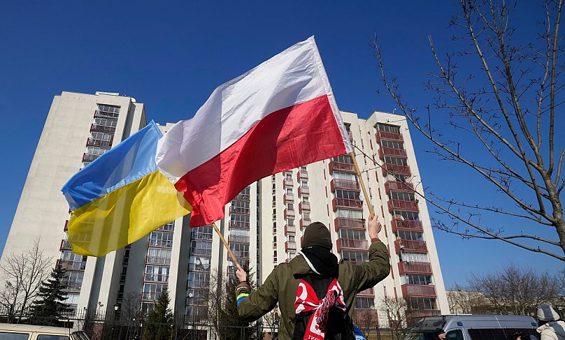 A man waves the Ukrainian and Polish flag during a demonstration in Warsaw, 13 March, 2022