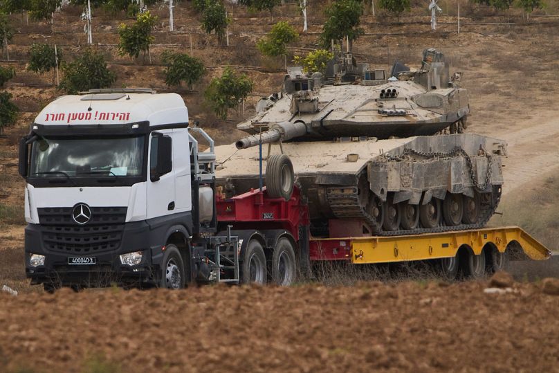 A truck carries a military tank from inside Gaza in southern Israel, following the announcement of a deal to pause the fighting, Thursday, Oct. 9, 2025