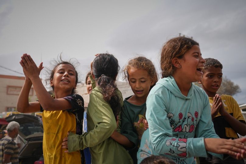 أطفال فلسطينيون يحتفلون بإعلان الاتفاق بين حماس وإسرائيل خارج مستشفى دير البلح 9 أكتوبر 2025 