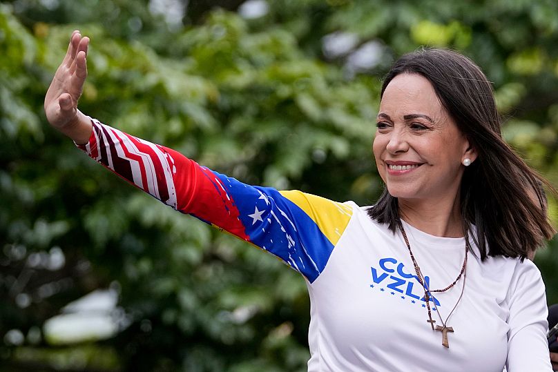 La dirigeante de l'opposition María Corina Machado salue depuis le haut d'un camion lors d'un meeting de campagne électorale à Caracas, le 25 juillet 2024