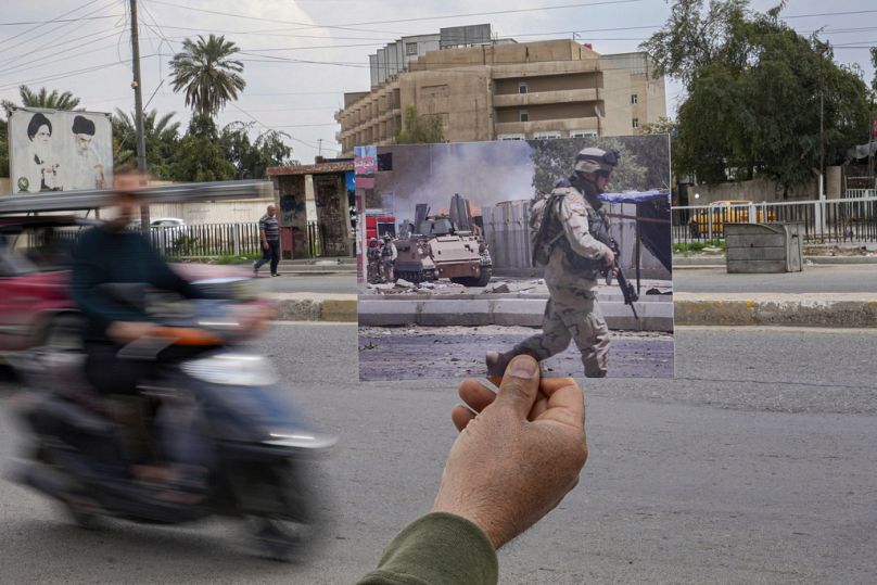 صورة لهجوم بسيارة مفخخة استهدف موكبًا عسكريًا أمريكيًا في بغداد عام 2005، تُعرض في الموقع نفسه بعد 20 عامًا على الغزو الأمريكي للعراق.