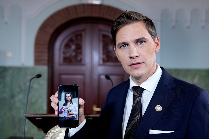 Le président du comité Nobel, Jørgen Watne Frydnes, montre une photo de María Corina Machado sur son téléphone portable à Oslo, le vendredi 10 octobre 2025