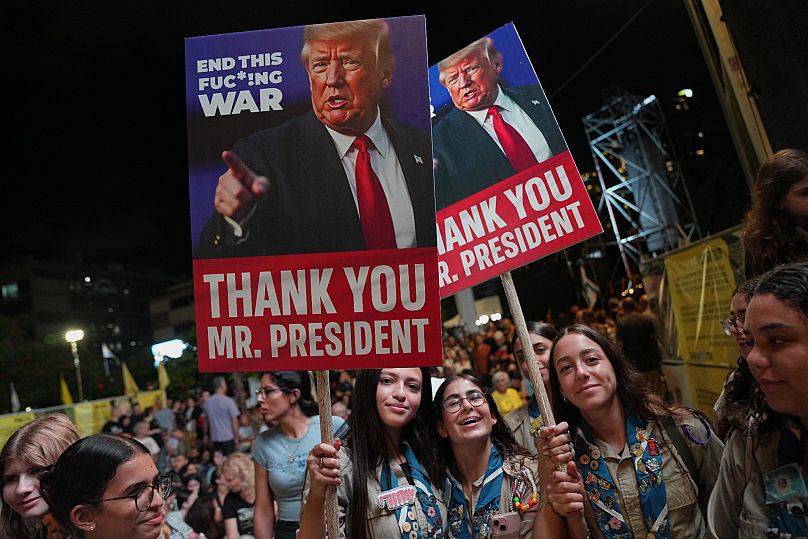 Cartelli con immagini raffiguranti il Presidente degli Stati Uniti Donald Trump partecipano a una manifestazione a sostegno degli ostaggi rapiti da Hamas, a Tel Aviv, in Israele, l'11 ottobre 2025.