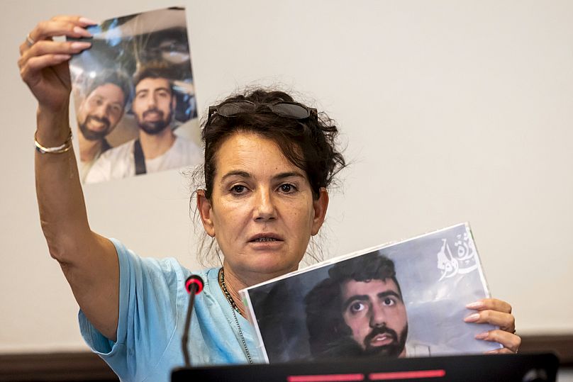 Merav Gilboa Dalal mother of hostage Guy Gilboa Dalal, holds pictures of her son at the European headquarters of the United Nations in Geneva, Switzerland, Aug. 12, 2025.