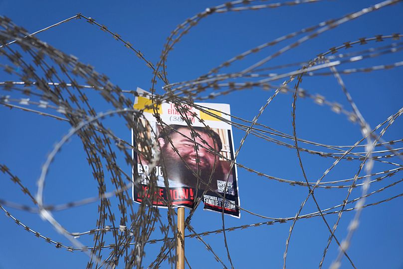 A picture of hostage Eitan Horn, held in Hamas captive in the Gaza Strip, hangs on a barbed wire during a protest in Tel Aviv, Israel, Saturday, Aug. 2, 2025. 