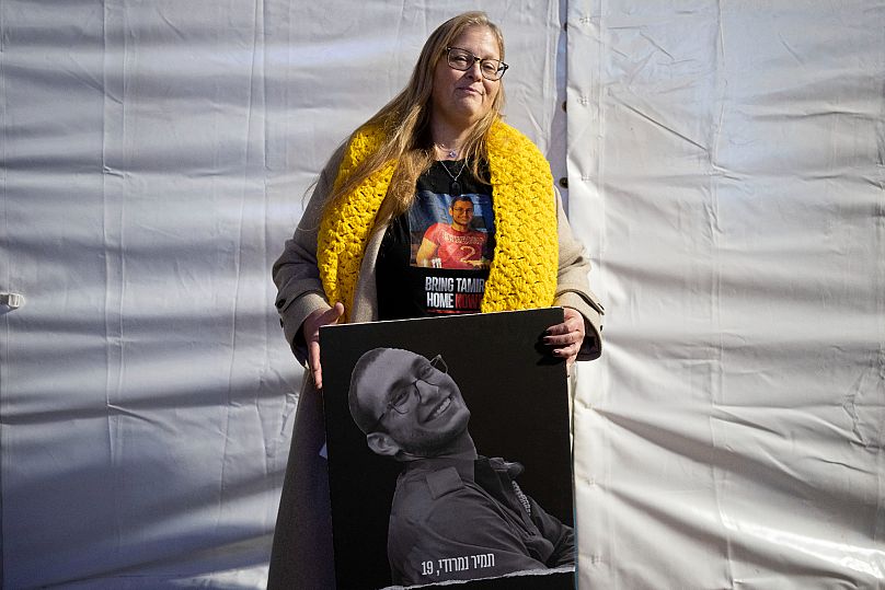 Herut Nimrodi poses for a portrait with a poster of her son, Tamir Nimrodi, an Israeli soldier who was abducted and brought to Gaza on Oct. 7, 2023, Tel Aviv, Jan. 14, 2025.