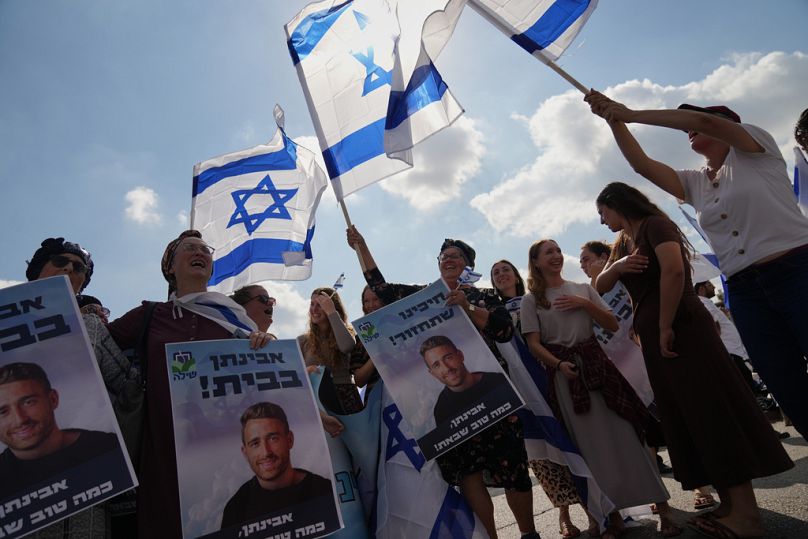 People wave Israeli flags in celebration as they wait outside Beilinson Hospital in Petah Tikva, Israel, where some of the freed hostages are expected to arrive after being re