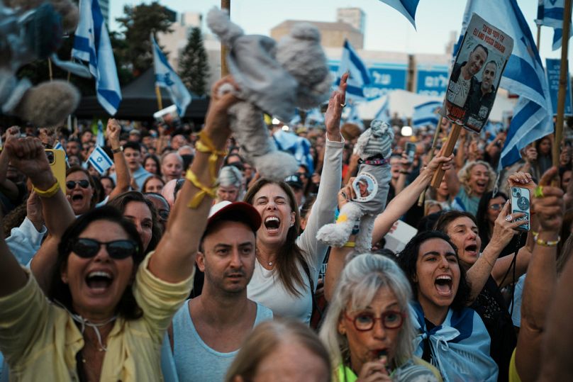 People react as they gather to watch a live broadcast of Israeli hostages released from Gaza at a plaza known as hostages square in Tel Aviv, Israel, Monday