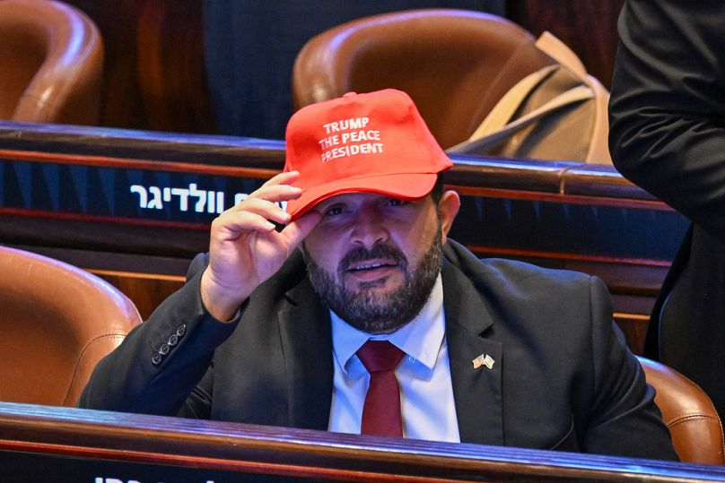 People wearing hats that read "Trump The Peace President" inside the Knesset as President Donald Trump prepares to deliver remarks, Monday, Oct. 13, 2025, in Jerusalem