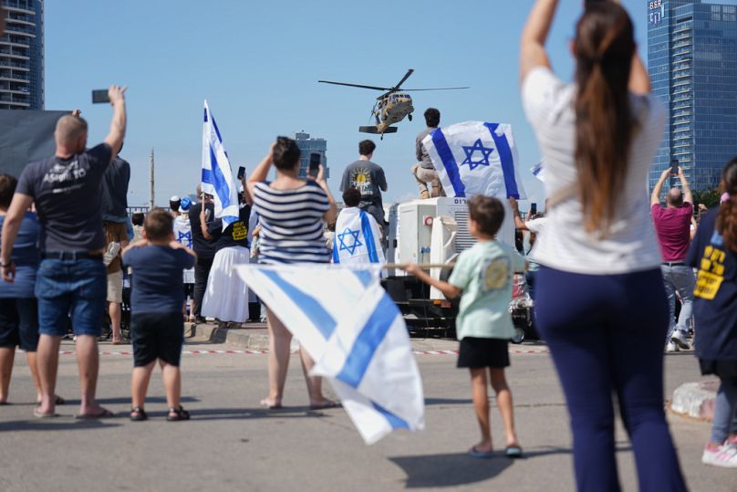 إسرائيليون ينظرون إلى مروحية عسكرية تقل الرهائن الإسرائيليين الذين أُفرج عنهم إلى مستشفى بيلنسون في بيتح تكفا بإسرائيل، بعد إطلاق سراحهم من أسر حركة حماس في قطاع غزة