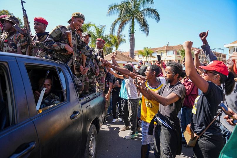 Soldiers are greeted by people gathering for a ceremony in tribute to demonstrators killed during anti-government protest in Antananarivo, Madagascar, Sunday, Oct. 12, 2025