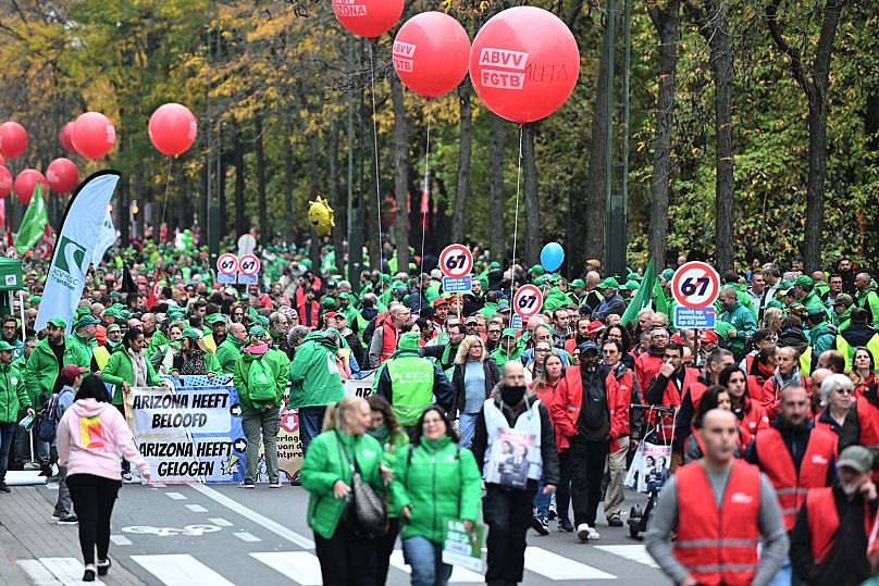 People march with signs crossed out with the number 67, referring to pension age, during a general strike in Brussels, 14 October, 2025