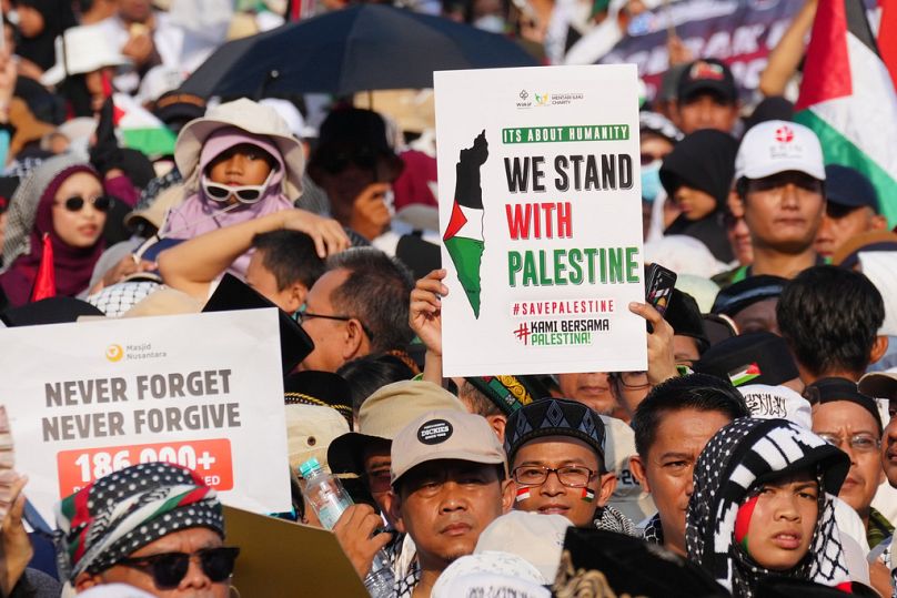 متظاهرون يرفعون لافتات خلال تجمع تضامني مع الفلسطينيين في غزة، في جاكرتا بإندونيسيا، في 12 أكتوبر 2025.