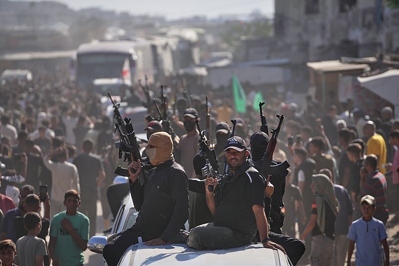 Des membres du Hamas escortent des bus transportant des prisonniers palestiniens libérés dans le cadre d'un accord entre le Hamas et Israël, à Khan Younès, le 13 octobre 2025