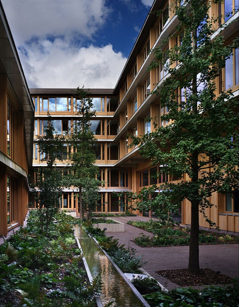 The layout places communal spaces at its heart to encourage interaction, while bay windows at street level connect residents to the outside world.