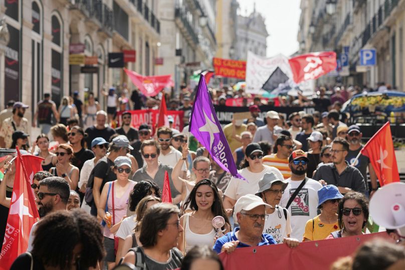 Ένας διαδηλωτής χρησιμοποιεί έναν φορητό ανεμιστήρα για να βοηθήσει στην καταπολέμηση της ζέστης κατά τη διάρκεια μιας διαμαρτυρίας ενάντια στην κρίση στέγασης που πλήττει την Πορτογαλία, στη Λισαβόνα,28 Ιουνίου 2025  