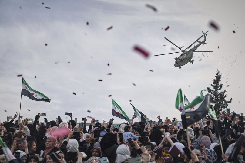Confetti and flowers are dropped from a helicopter during a celebration marking the 10th years since the victory of rebel forces over al-Assad's army in Idlib, 28 March 2025