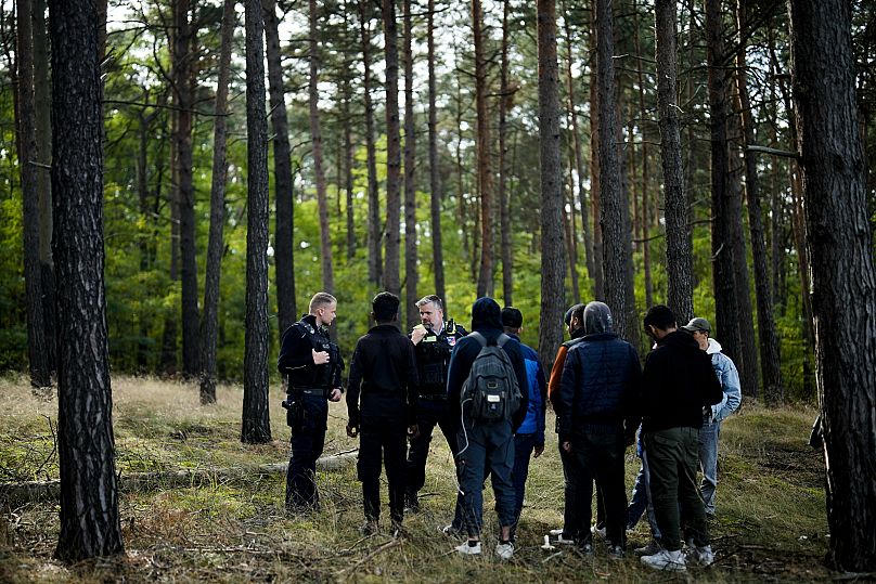 A police officer speaks into his radio as he and a colleague track down a group of migrants who illegally crossed the border from Poland into Germany, 11 October, 2023