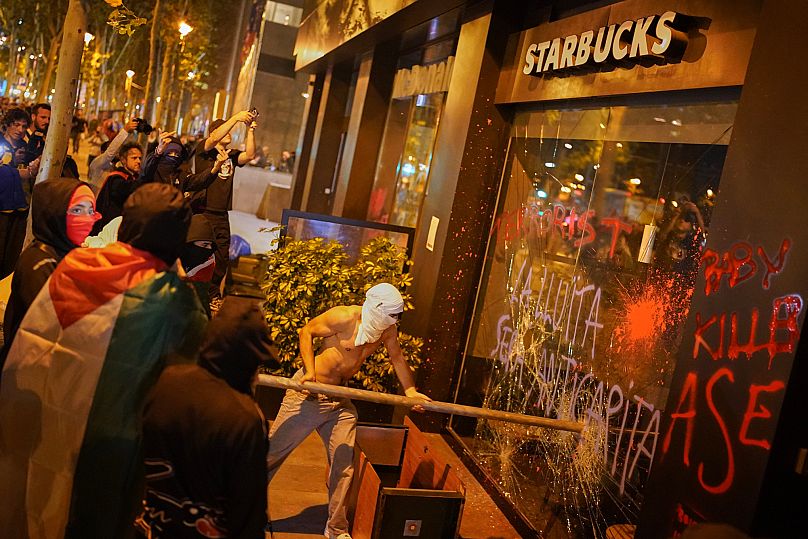 Manifestantes rompen el escaparate de un Starbucks durante una protesta en apoyo a los palestinos en Barcelona, ​​el 15 de octubre de 2025.
