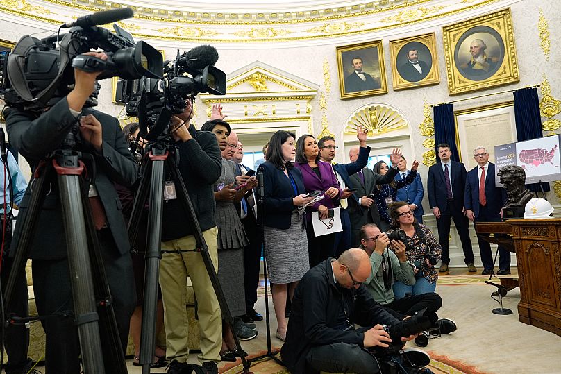 Reporters and photographers listen as President Donald Trump speaks in the Oval Office of the White House, Friday, Oct. 10, 2025, in Washington. (AP Photo/Alex Brandon)