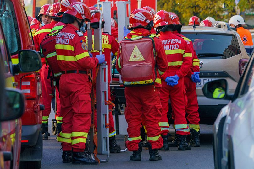 Equipas de emergência em frente a um edifício residencial danificado após uma forte explosão num bloco residencial em Bucareste, 17 de outubro de 2025