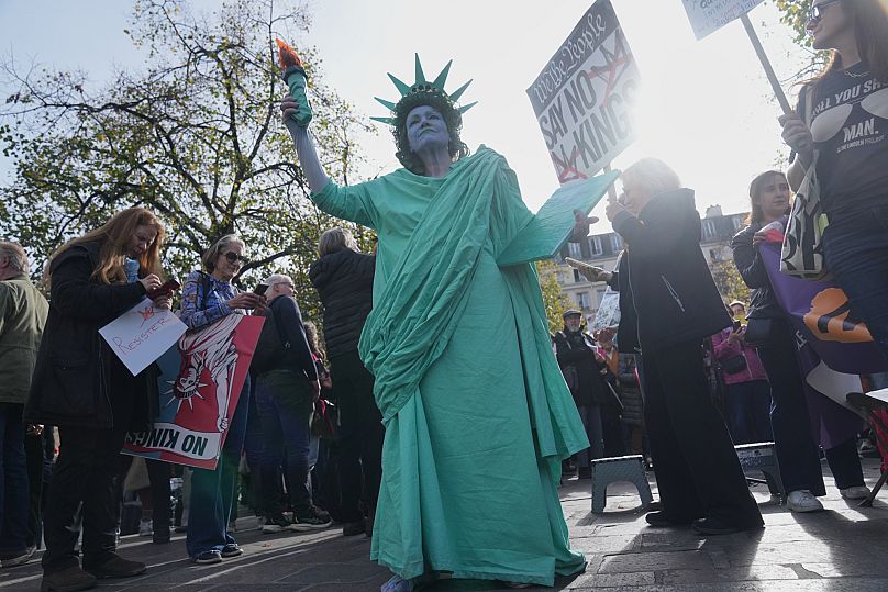 A woman dressed like the Statue of Liberty attends a protest against U.S. President Donald Trump, in Paris, Saturday, Oct. 18, 2025.