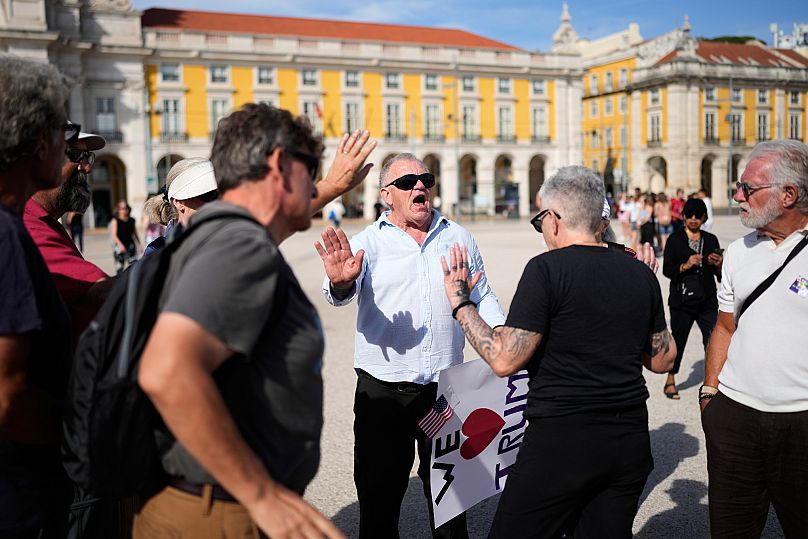 A man carrying a pro-Trump poster argues with people participating in a No Kings protest organized by US citizens living in Portugal, in downtown Lisbon, Oct. 18, 2025.
