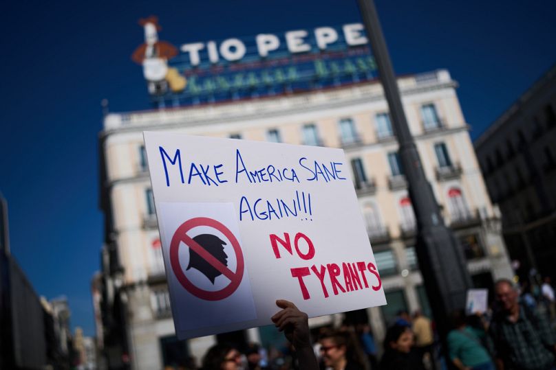 Ένας διαδηλωτής κρατάει μια πινακίδα κατά τη διάρκεια μιας διαδήλωσης κατά του Τραμπ, στη Μαδρίτη, Ισπανία, Σάββατο, 18 Οκτωβρίου 2025
