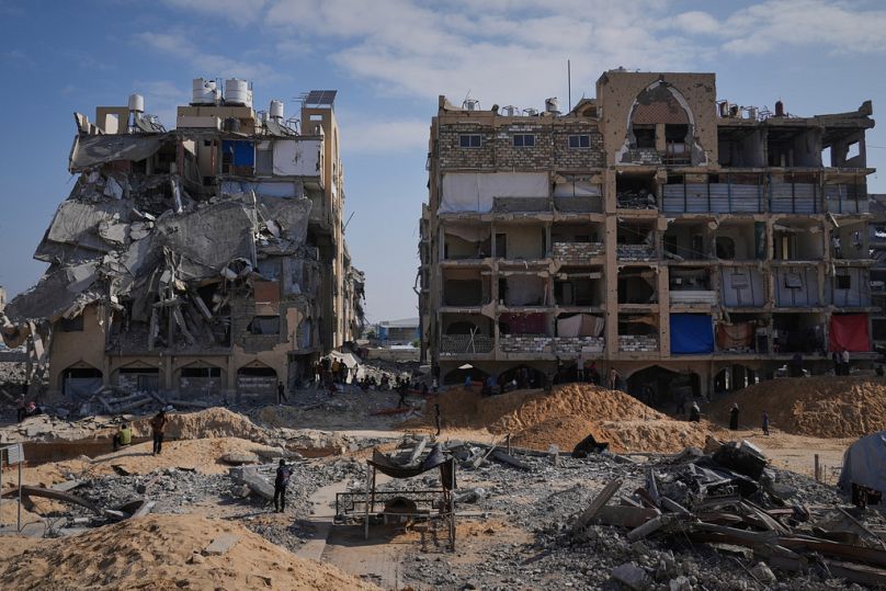 Miembros de Hamás buscan bajo tierra los cuerpos de rehenes israelíes entre edificios destruidos en Jan Yunis, en el sur de la Franja de Gaza, domingo 19 de octubre de 2025.