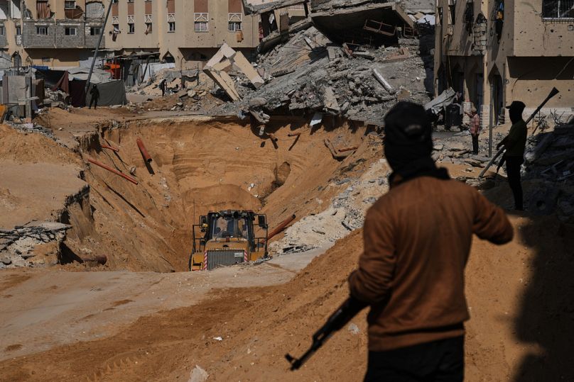 Members of Hamas search underground for the bodies of Israeli hostages amid destroyed buildings in Khan Younis, in the southern Gaza Strip, Sunday, Oct. 19, 2025