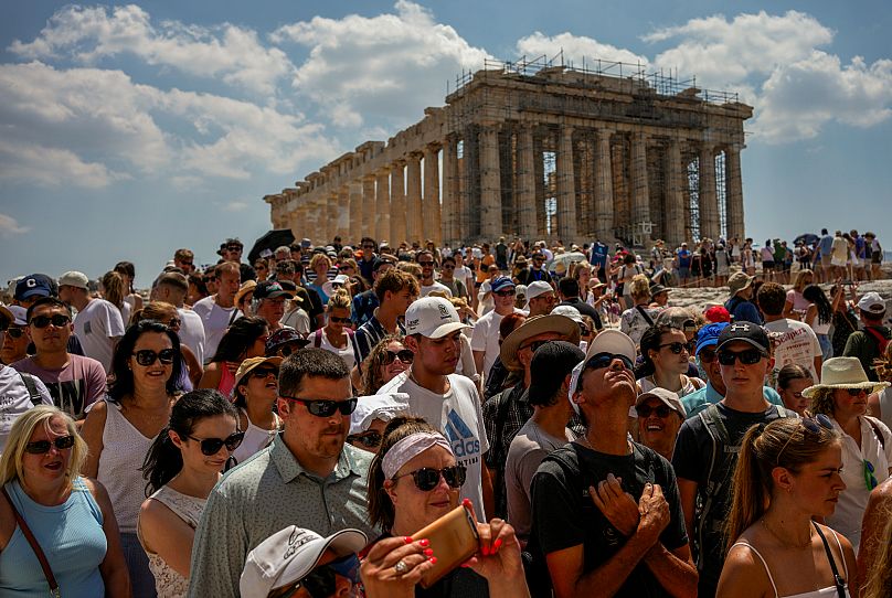 No topo da antiga colina da Acrópole, turistas visitam o templo do Partenon, em Atenas, Grécia, terça-feira, 4 de julho de 2023
