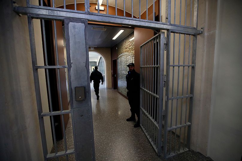 ZDJĘCIE ARCHIWALNE – Ochroniarze stoją przy bramie więzienia La Santé podczas wizyty prasowej po czteroletnim projekcie renowacji w Paryżu, piątek, 12 kwietnia 2019 r