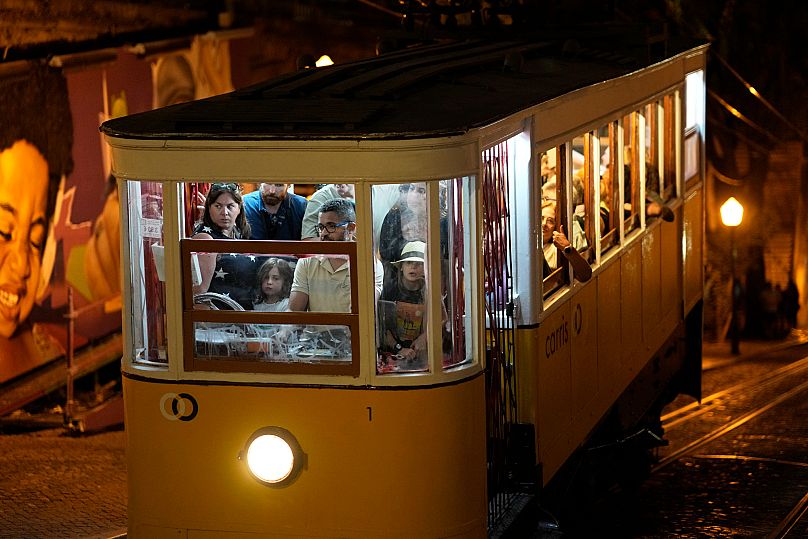 FILE - Tourists pack the Gloria funicular arriving at Bairro Alto, or High Quarter, from downtown Lisbon, on Aug. 17, 2023. (AP Photo/Armando Franca, File)