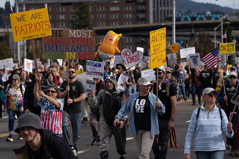 People march across the Morrison Bridge during a "No Kings" protest in Portland, Ore., on Saturday, Oct. 18, 2025. (AP Photo/Jenny Kane)