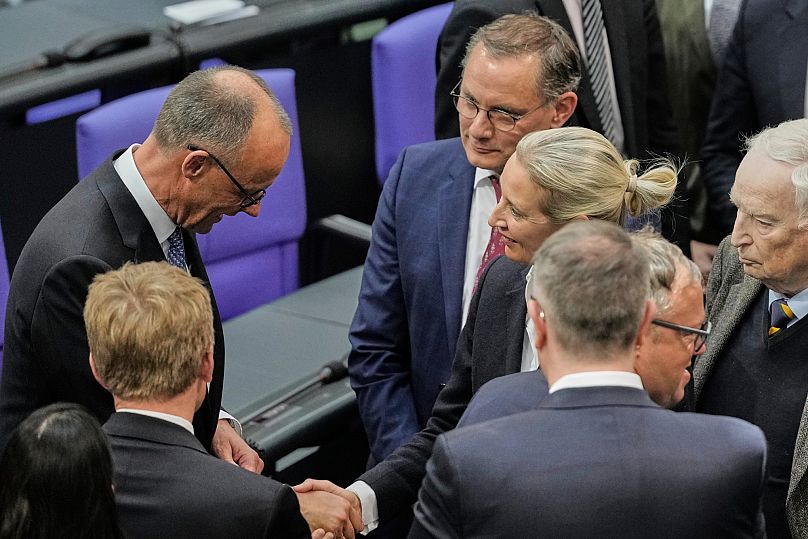Le chancelier Friedrich Merz (CDU) serre la main de la présidente du parti AfD Alice Weidel au Bundestag.