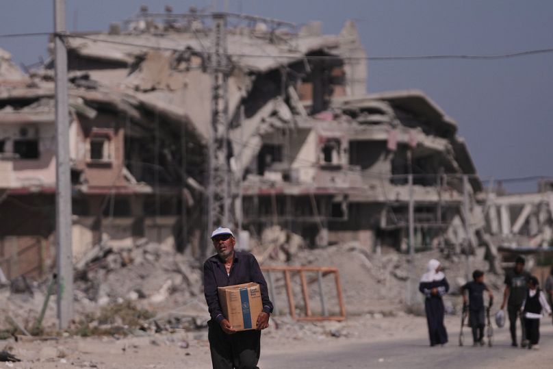 رجل فلسطيني يحمل صندوقاً من المساعدات الغذائية التابعة لبرنامج الأغذية العالمي في خان يونس جنوب قطاع غزة، في 20 أكتوبر 2025.