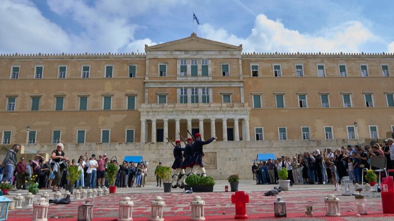 Tourists watch the changing of the guard at the Tomb of the Unknown Soldier in front of the Greek parliament, in Athens, Tuesday, Oct. 21, 2025