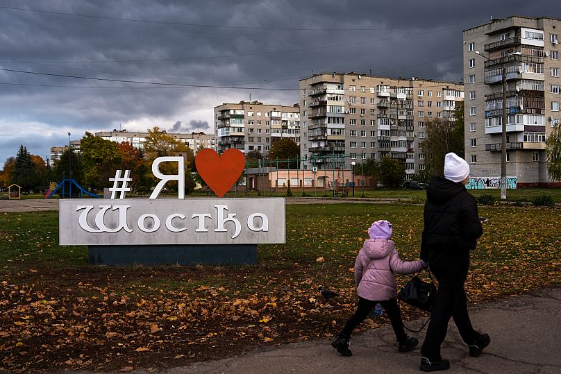 Des gens marchent dans Shostka pendant une coupure de courant, le 16 octobre 2025.